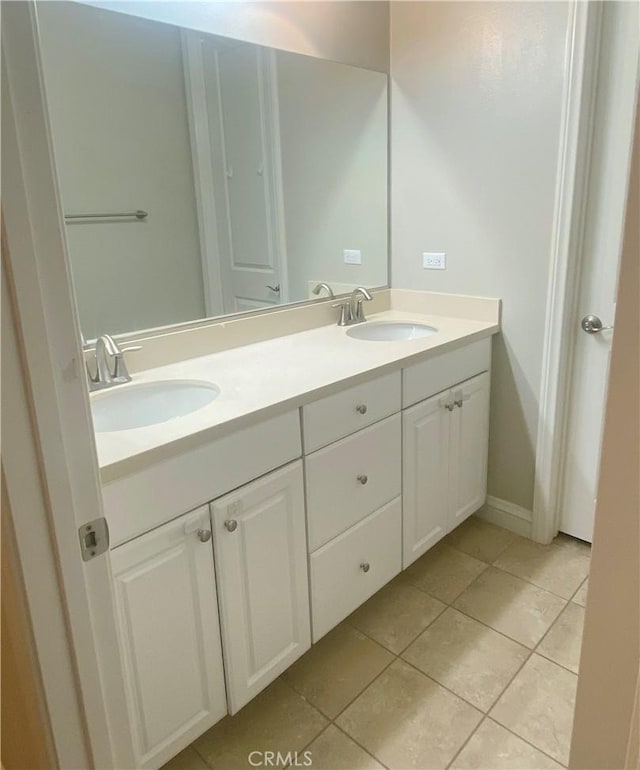 bathroom featuring tile patterned flooring, a sink, and double vanity