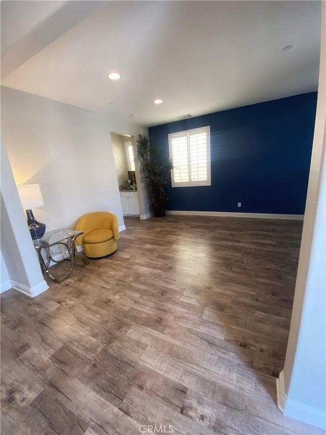 unfurnished room with baseboards, wood finished floors, and recessed lighting