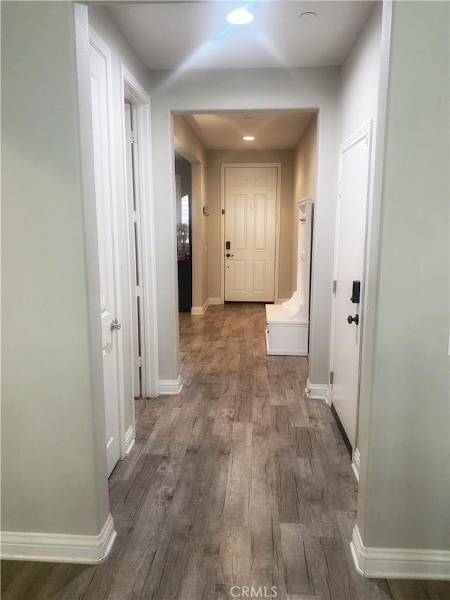 corridor featuring wood finished floors and baseboards