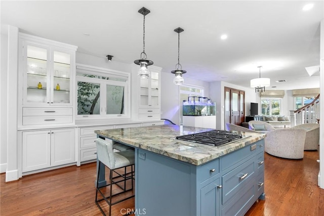 236 7th St, Seal Beach, CA 90740 - kitchen featuring white cabinets, stainless steel gas stovetop, dark wood-style floors, glass insert cabinets, and pendant lighting