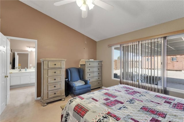 bedroom featuring a ceiling fan, light carpet, ensuite bath, and vaulted ceiling