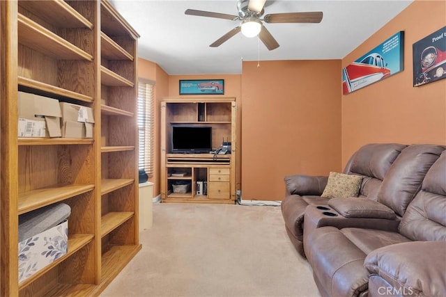 carpeted living area with ceiling fan