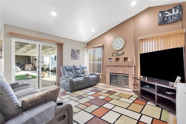 living area featuring lofted ceiling, recessed lighting, and a fireplace