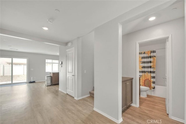 hall with baseboards, light wood-type flooring, stairs, and recessed lighting