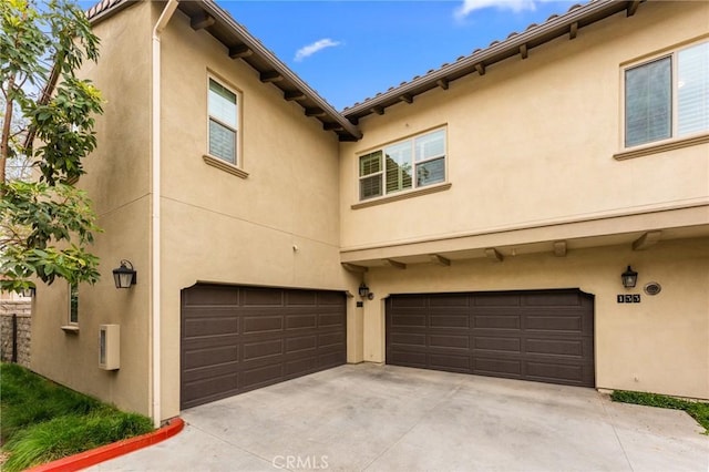 133 Lantana Dr, Stanton, CA 90680 - back of property with stucco siding, a garage, and concrete driveway