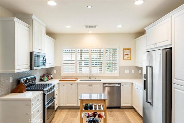 133 Lantana Dr, Stanton, CA 90680 - kitchen with stainless steel appliances, a sink, light countertops, white cabinets, and recessed lighting