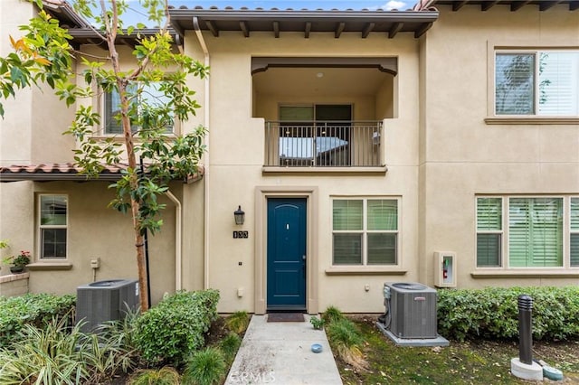 133 Lantana Dr, Stanton, CA 90680 - doorway to property with central air condition unit, a balcony, and stucco siding