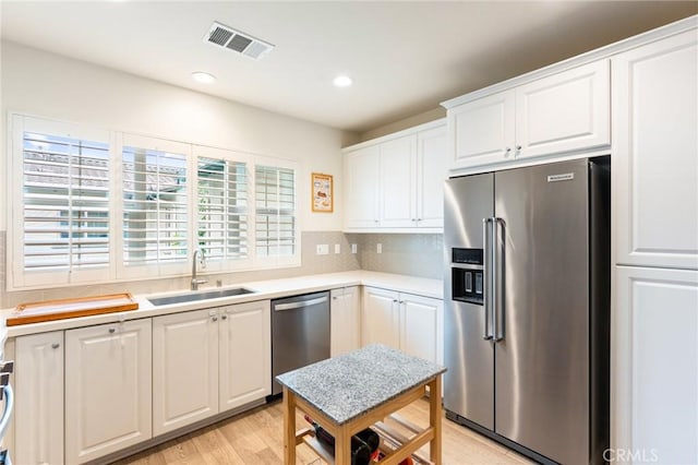 133 Lantana Dr, Stanton, CA 90680 - kitchen with stainless steel appliances, a sink, white cabinetry, light countertops, and recessed lighting