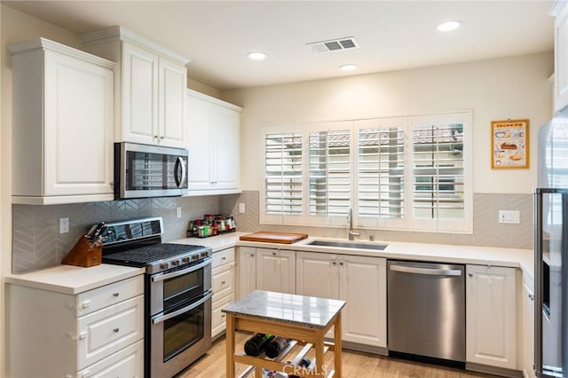 133 Lantana Dr, Stanton, CA 90680 - kitchen featuring stainless steel appliances, a sink, white cabinets, light countertops, and recessed lighting