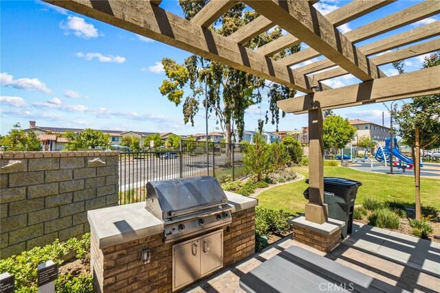 133 Lantana Dr, Stanton, CA 90680 - view of patio with exterior kitchen, a playground, a pergola, and a residential view