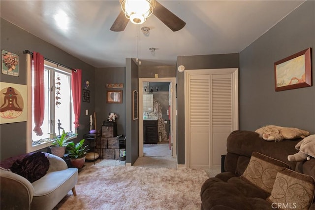 carpeted living area featuring a ceiling fan