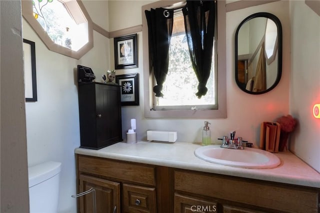 bathroom featuring vanity, a wealth of natural light, and toilet