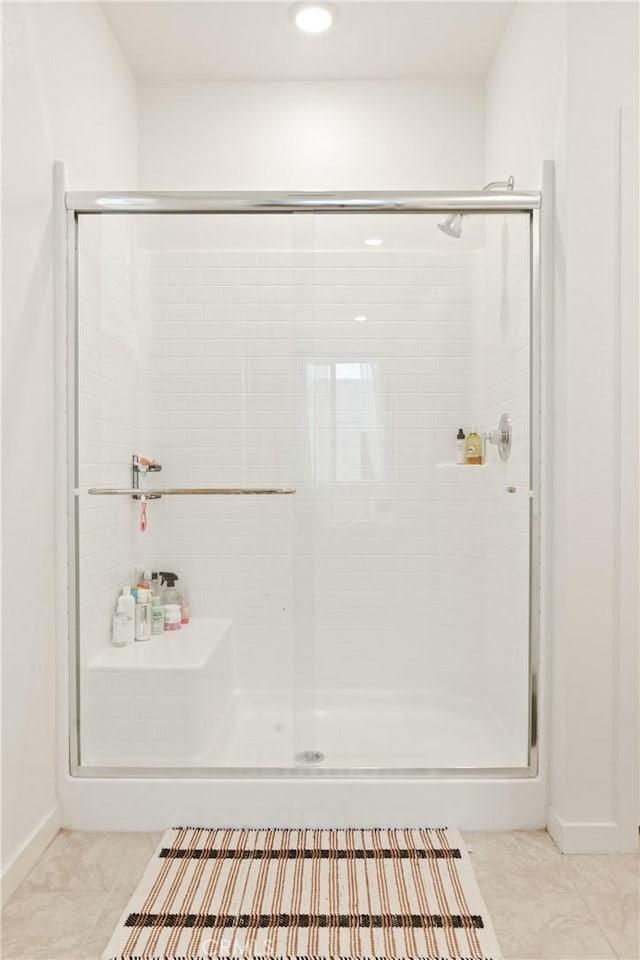 bathroom featuring baseboards, tile patterned flooring, a shower stall, and recessed lighting
