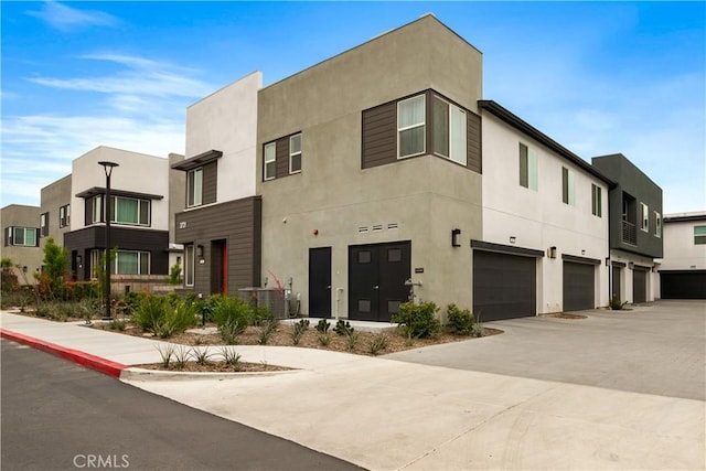 view of front of home with a garage, stucco siding, and driveway