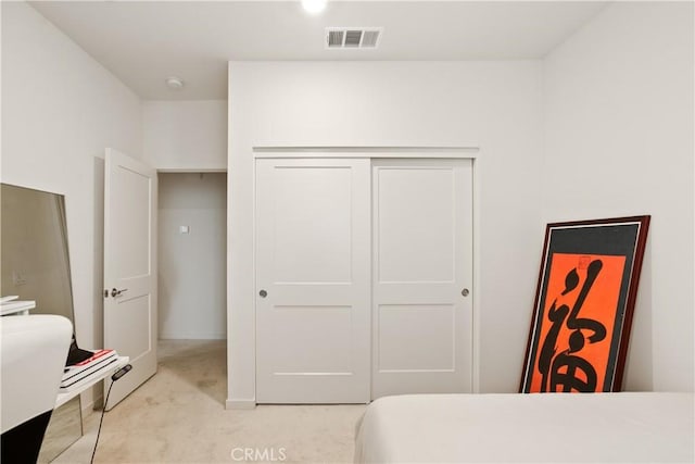 bedroom with visible vents, baseboards, a closet, and light colored carpet