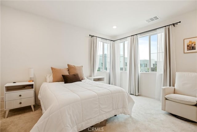 bedroom featuring visible vents, recessed lighting, multiple windows, and light carpet
