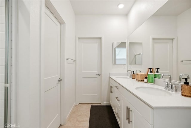 bathroom featuring double vanity, a sink, and recessed lighting