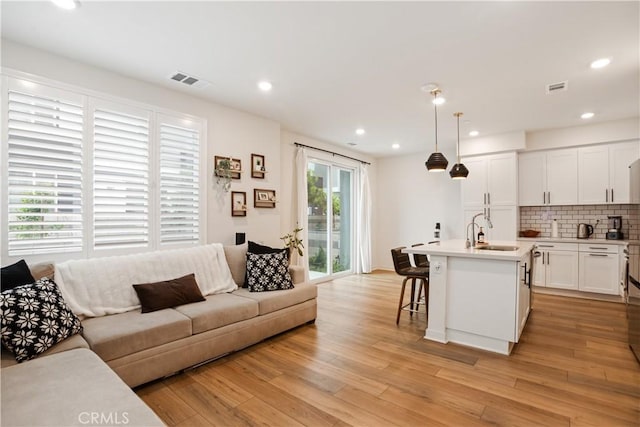 living room featuring recessed lighting, visible vents, and light wood finished floors