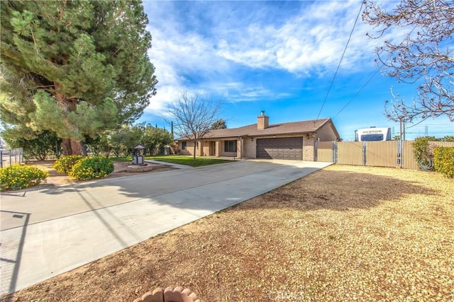 ranch-style house featuring concrete driveway, a chimney, a gate, an attached garage, and fence