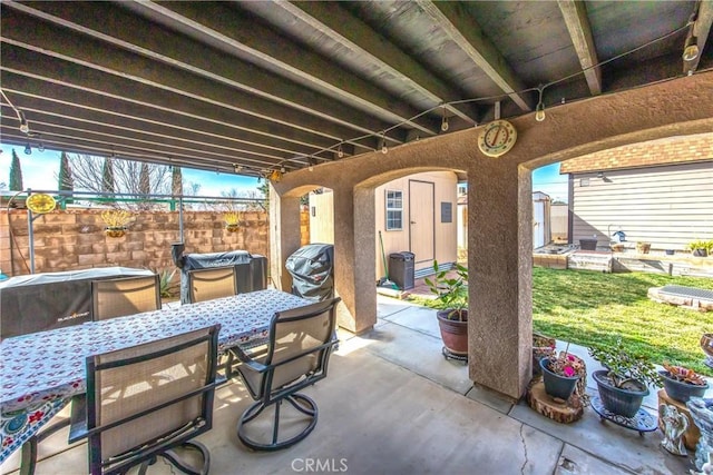 view of patio / terrace featuring outdoor dining space, a shed, and an outdoor structure