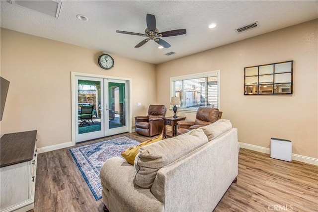 living area featuring visible vents, baseboards, and wood finished floors