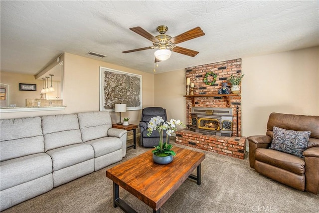 living area with carpet flooring, visible vents, a textured ceiling, and a ceiling fan