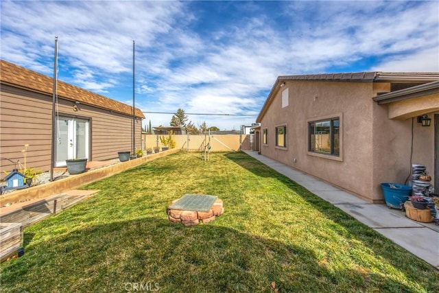 view of yard featuring french doors and fence