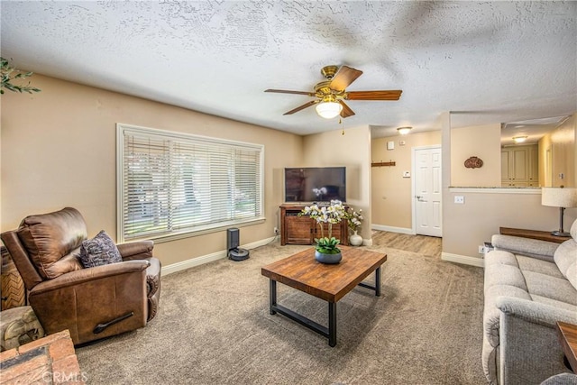 carpeted living room with baseboards, a ceiling fan, and a textured ceiling