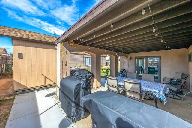 view of patio / terrace featuring a storage shed, an outbuilding, and outdoor dining area