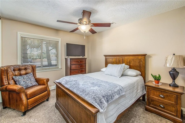 bedroom featuring a ceiling fan, light colored carpet, and a textured ceiling