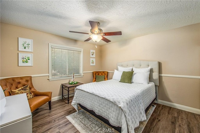 bedroom featuring a textured ceiling, wood finished floors, baseboards, and a ceiling fan