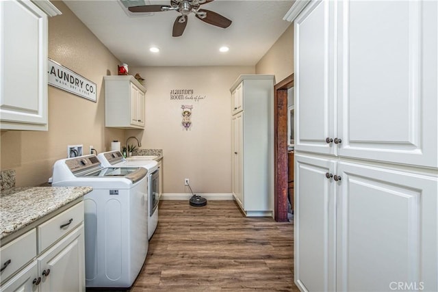 clothes washing area with cabinet space, a ceiling fan, wood finished floors, a sink, and washing machine and dryer