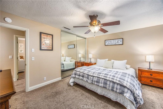 carpeted bedroom with a textured ceiling, a closet, a ceiling fan, visible vents, and baseboards