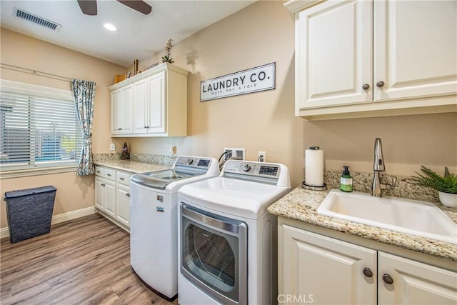 laundry area featuring visible vents, washer and dryer, a sink, ceiling fan, and cabinet space