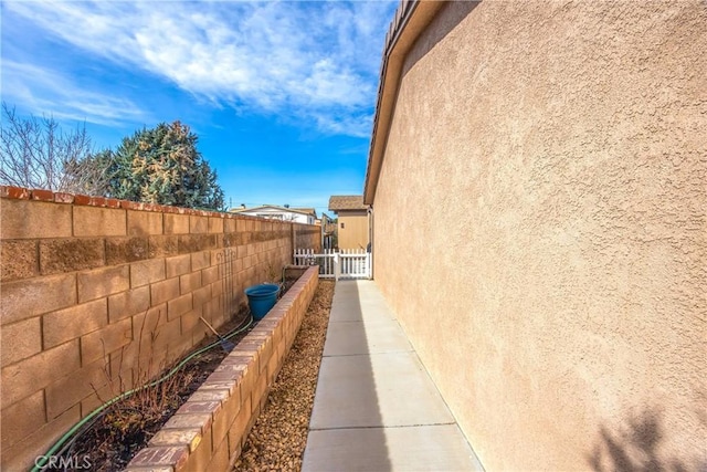 view of side of property featuring stucco siding and fence