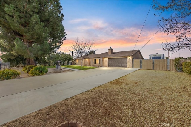 view of front of property featuring a chimney, a gate, driveway, an attached garage, and fence