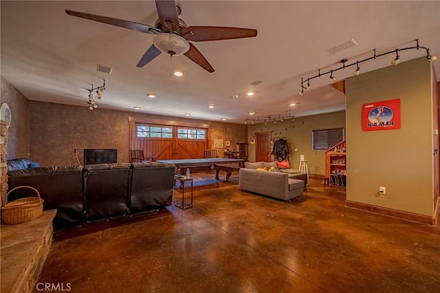 living area featuring baseboards, recessed lighting, rail lighting, and finished concrete flooring