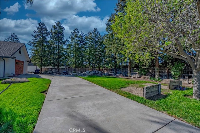 view of yard with driveway and fence