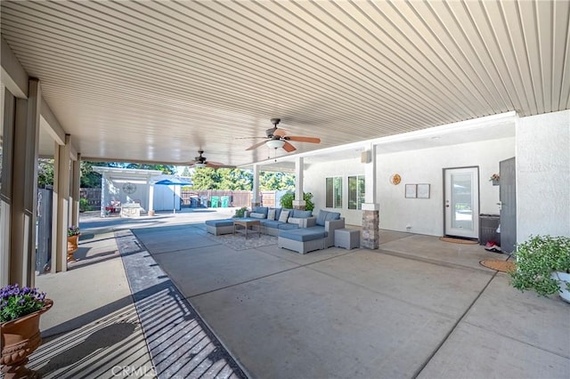 view of patio / terrace featuring an outdoor structure, a fenced backyard, outdoor lounge area, a ceiling fan, and a shed