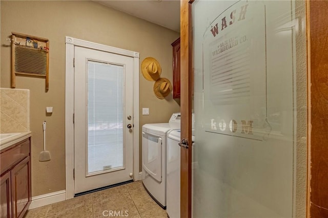 laundry area with light tile patterned floors, cabinet space, independent washer and dryer, and baseboards