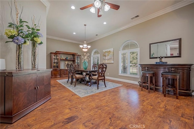 dining space featuring baseboards, recessed lighting, ornamental molding, wood finished floors, and ceiling fan with notable chandelier