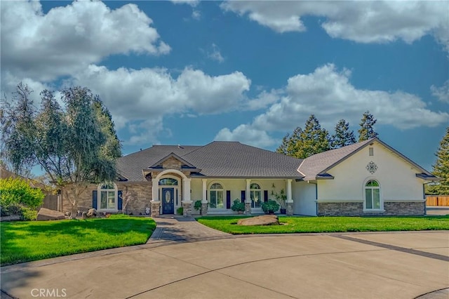 view of front of home with a front lawn, stucco siding, concrete driveway, and stone siding