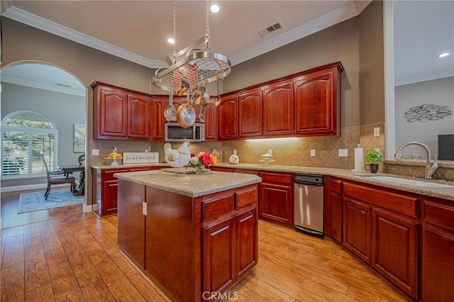 kitchen featuring visible vents, a sink, light wood-style flooring, and stainless steel microwave