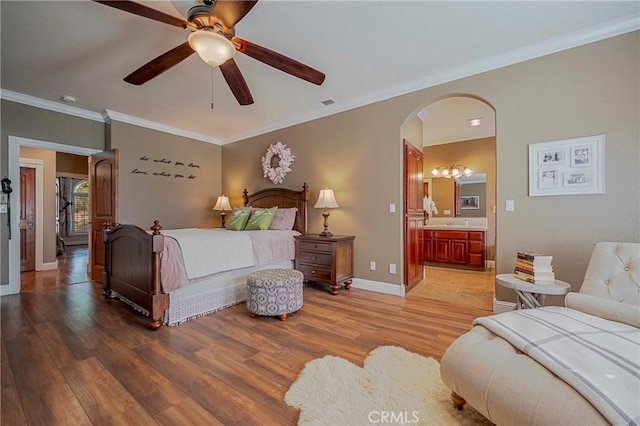 bedroom featuring wood finished floors, ornamental molding, arched walkways, and baseboards