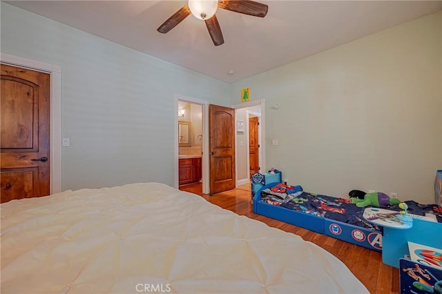 bedroom with wood finished floors, connected bathroom, and a ceiling fan
