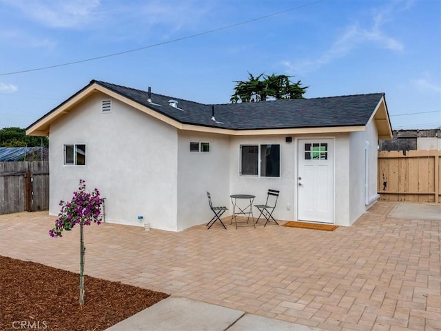 1912 8th St, Los Osos, CA 93402 - rear view of house with fence, a shingled roof, stucco siding, and a patio area