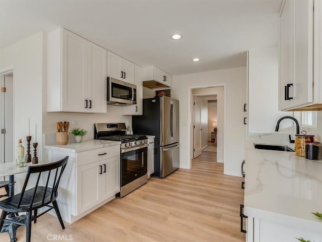 1912 8th St, Los Osos, CA 93402 - kitchen with light wood-style floors, recessed lighting, white cabinets, a sink, and stainless steel appliances