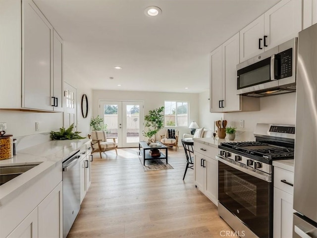 1912 8th St, Los Osos, CA 93402 - kitchen featuring white cabinets, appliances with stainless steel finishes, light stone counters, light wood-style flooring, and recessed lighting