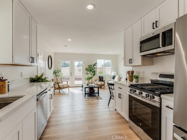 1912 8th St, Los Osos, CA 93402 - kitchen with stainless steel appliances, light wood-style flooring, white cabinetry, recessed lighting, and light stone counters