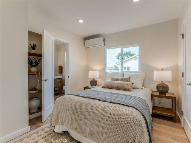 1912 8th St, Los Osos, CA 93402 - bedroom featuring baseboards, a wall mounted AC, and light wood-style floors